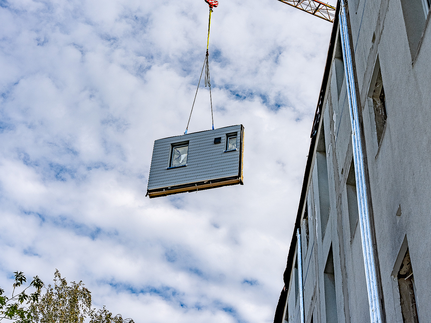Beim Sanierungsprojekt in Merseburg-Süd werden die Fassaden im Werk vorgefertigt und auf der Baustelle mit einem Kran an ihre Position gebracht.