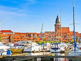 Stadthafen von Waren mit vielen Botten und im Hintergrund die Stadt Waren 
