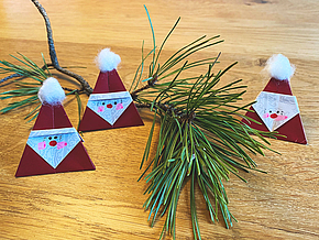 Kleine Weihnachtsmänner, die nach dem Origami-Prinzip gefaltet sind.