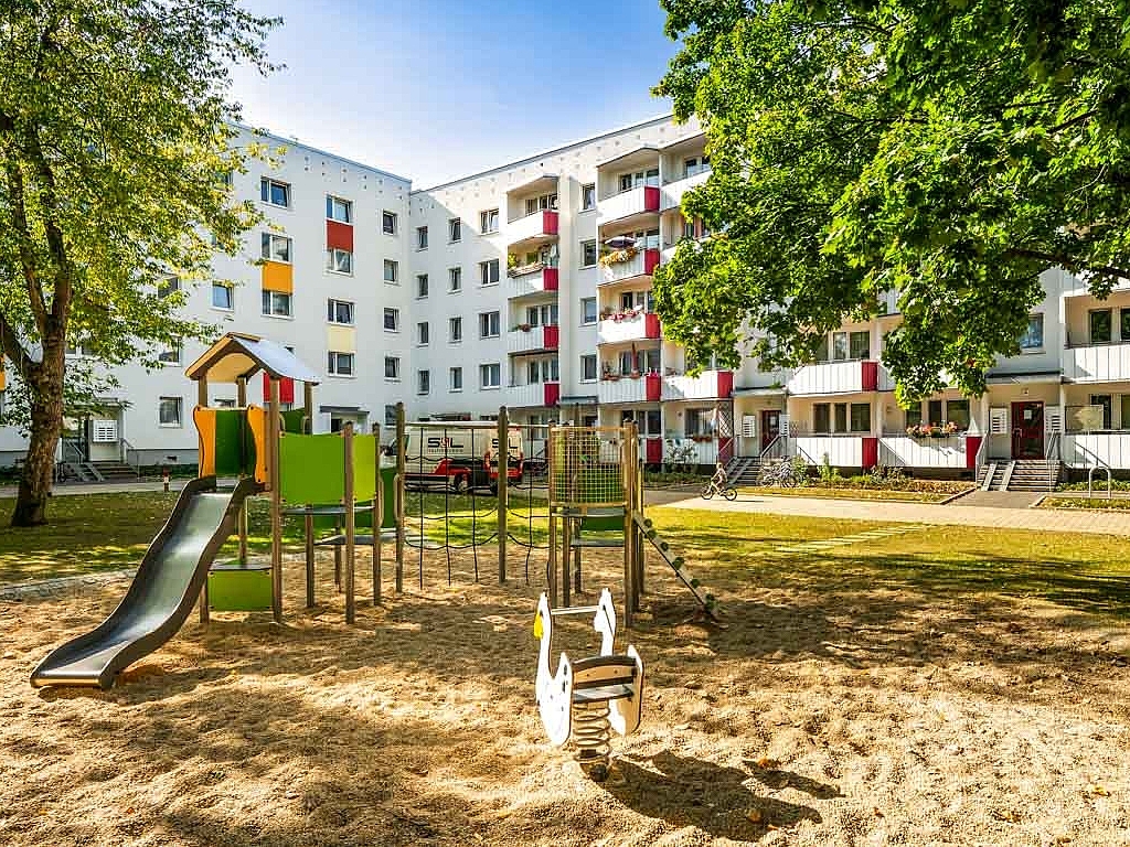 Ein einladender Sandspielplatz mit Klettergerüst und Rutsche im Erfurter Wohnquartier Berliner Platz