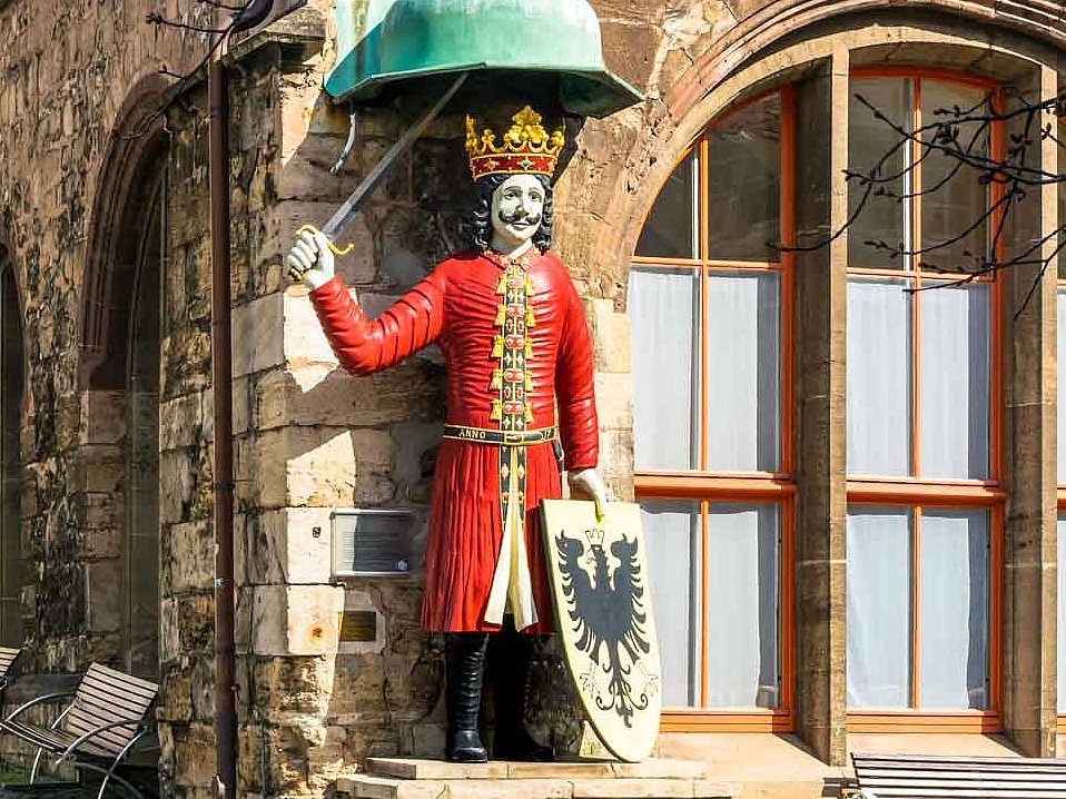 Das Wahrzeichen Nordhausens: Ein majestätischer König in rotem Gewand mit Krone, Schwert und Schild