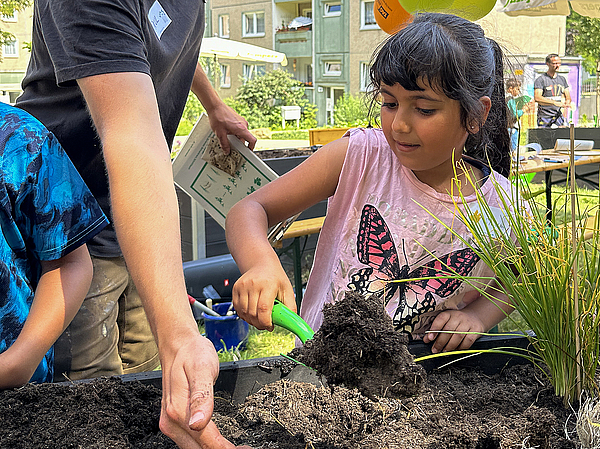 Bevor der Schnittlauch wachsen konnte, musste ein passendes Pflanzloch gegraben werden, wobei die Jumpers-Kinder mit großem Eifer halfen.