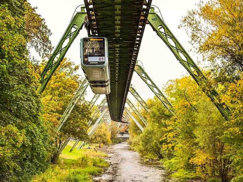 Schwebebahn im Wuppertal umgeben von Bäumen