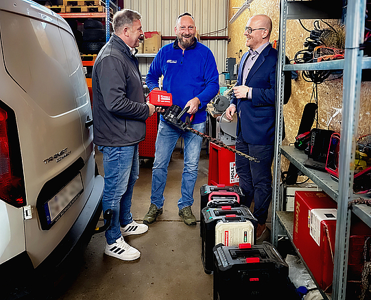  Christian Zimmermann mit zwei Kollegen in der Werkstatt im Gespräch.