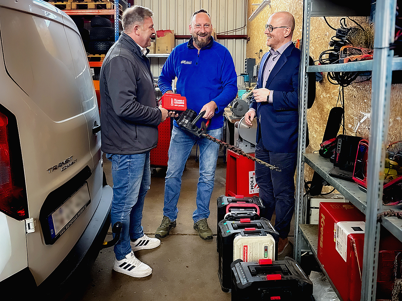  Christian Zimmermann mit zwei Kollegen in der Werkstatt im Gespräch.