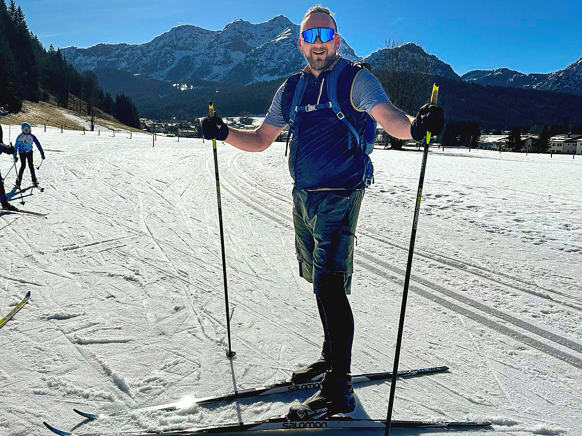 Christian Zimmermann läuft Langlaufski vor einer schönen Bergkulisse. 