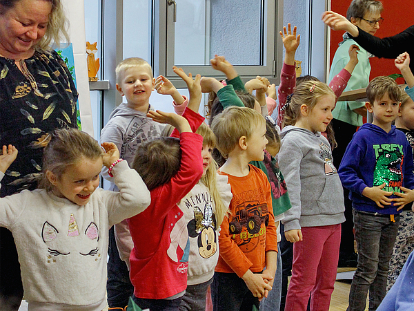 Kinder der Kita Traumland singen mit Erzieherin Lieder für die Gäste