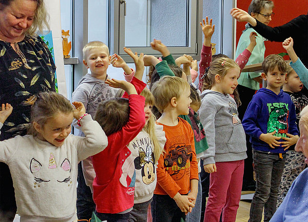 Kinder der Kita Traumland singen mit Erzieherin Lieder für die Gäste