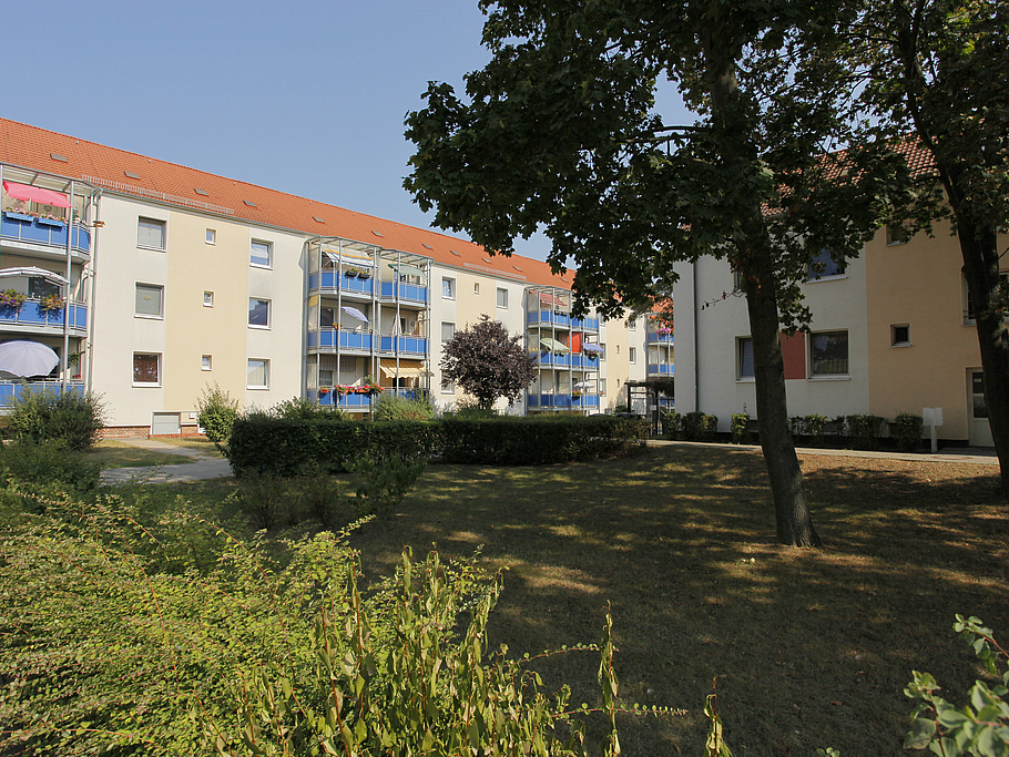 Cremfarbenes Mehrfamilienhaus mit Balkonen mit Grünfläche in Brandenburg an der Havel
