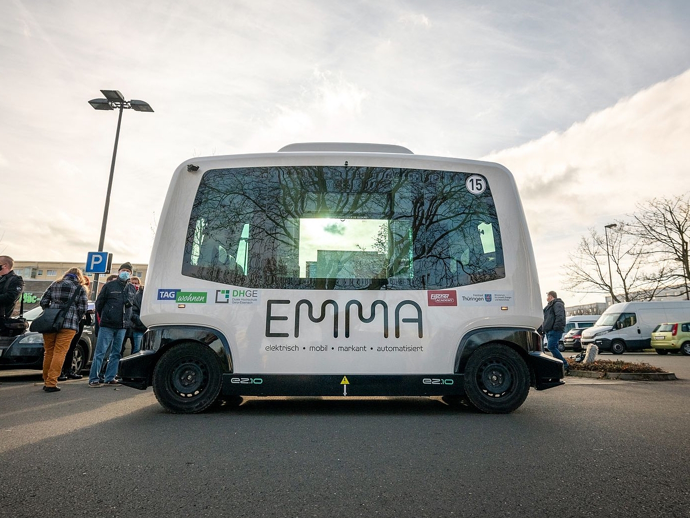 Auf einem Parkplatz steht der kleine Shuttlebus "EMMA"