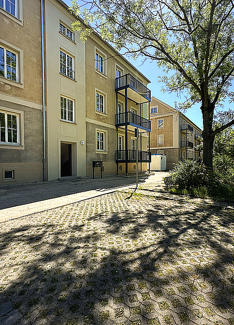 Sanierungsprojekt Biethe: Erstbezug nach Sanierung in der Mittel Frisch sanierter Altbau aus den 1950er Jahren mit gereinigter sandfarbener Fassade und neu angebauten großen Balkonen mit dunkler, dezenter Balkonbrüstung im Wohnquartier Biethe in Dessau-Roßlau