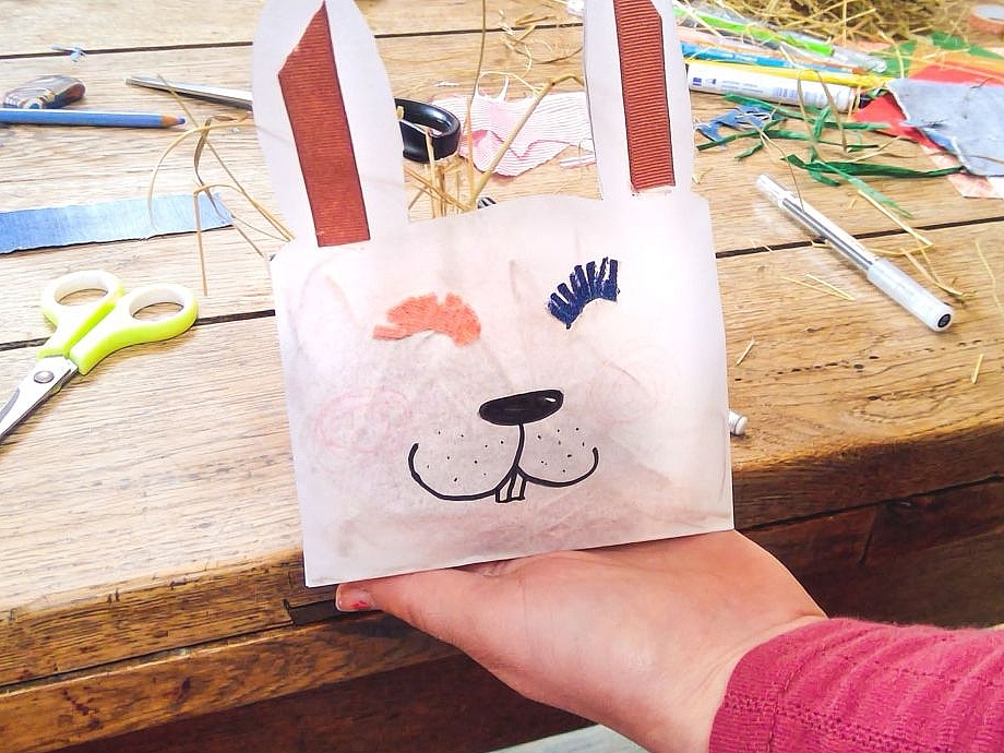 Auf eine Papiertüte wurde das Gesicht eines Hasen gemalt und in die Papiertüte wurden Hasenohren geschnitten.