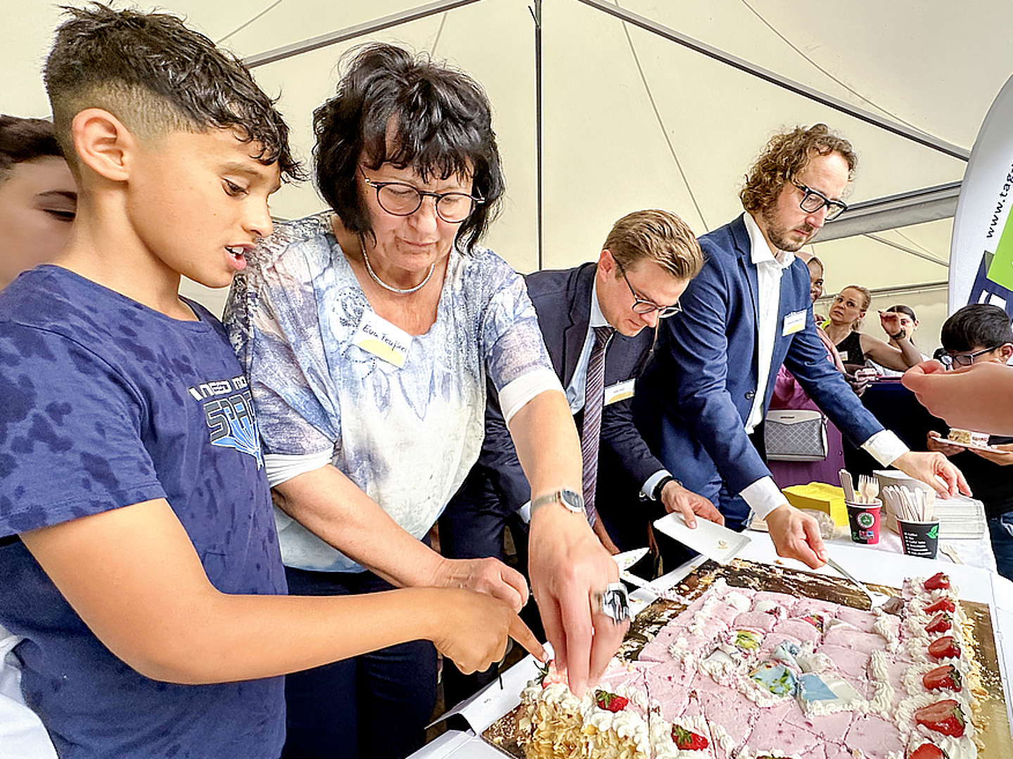 Bildungsministerin Eva Feußner, Staatssekretär Sven Haller und Oberbürgermeister Sebastian Müller-Bahr schnitten zusammen die riesengroße Erdbeertorte an (v.l.n.r.).  