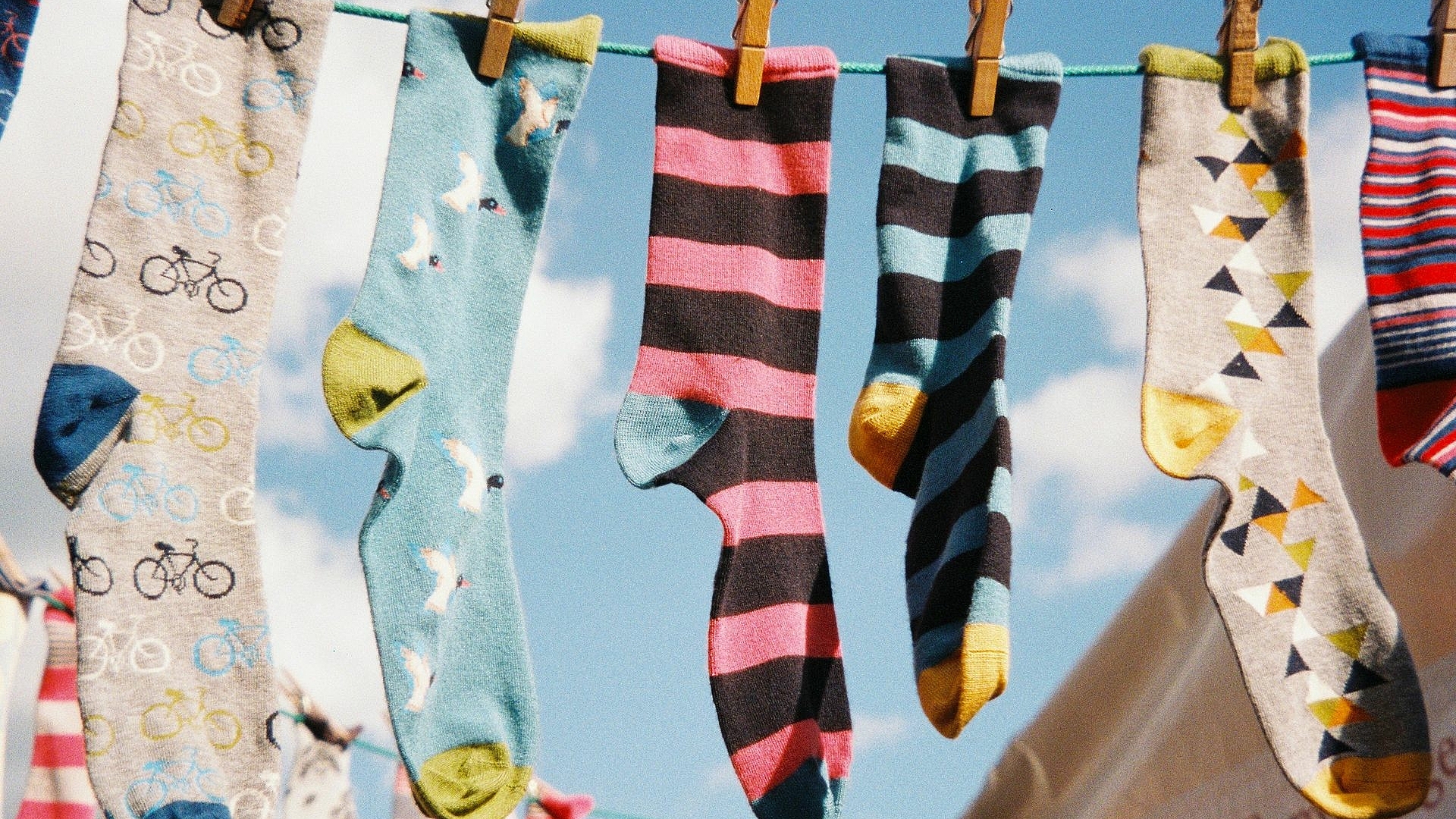 Viele bunte Socken hängen auf einer Wäscheleine.